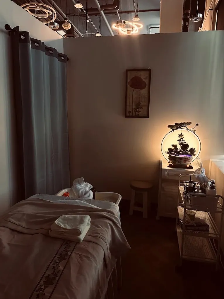 Private massage room with warm lamplight and a made-up table at Pacific Massage & Head Spa, Redmond