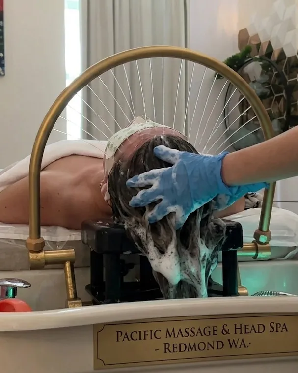 Guest reclined at the gold hydrotherapy basin during a Japanese-style head spa session at Pacific Massage & Head Spa in Redmond, WA